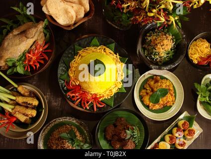 Tumpeng Nasi Nusantara. Ambiance festive et grand Rijsttafel indonésienne de riz jaune en forme de cône avec sept plats d'inspiration régionale. Banque D'Images