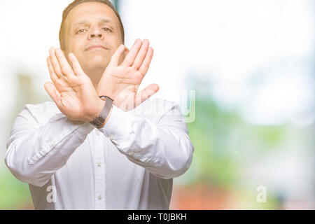 L'âge moyen homme élégant arabes sur fond isolé de l'expression de rejet d'une barrière et les paumes faisant face en colère, de signe négatif Banque D'Images