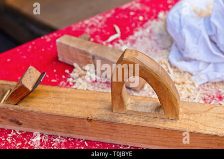 Menuiserie en bois de chauffage, sur une table recouverte de tissu rouge Banque D'Images