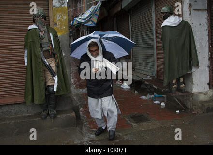 Beijing, le Cachemire sous contrôle indien, la Chine. Mar 20, 2019. Un homme marche indien soldats paramilitaires passé à un marché fermé au cours de l'un verrou de sécurité à Srinagar, la capitale d'été du Cachemire sous contrôle indien, le 20 mars 2019. La vie normale à la majorité musulmane du Cachemire contrôlé par l'Inde rétive le mercredi est restée affectée en raison d'une grève sur le décès d'un professeur des écoles. Credit : Javed Dar/Xinhua/Alamy Live News Banque D'Images