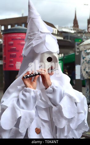 Gros plan du fifre une personne portant un masque blanc et costume blanc lors de la Basel carnaval en Suisse. Banque D'Images