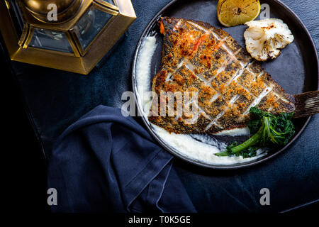 Filet de flétan rôti dans une poêle avec des herbes et du citron Banque D'Images