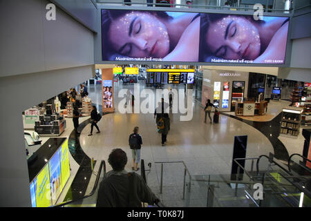 Angleterre Heathrow Airport Terminal 2 passager sur Escalator par les boutiques hors taxes dans la salle des départs Banque D'Images