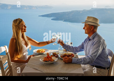 L'homme et de la femme en train de dîner dans un restaurant sur le fond de la mer, l'île de Santorin, Grèce Banque D'Images