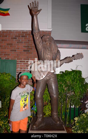 Jeune fille posant à côté de la statue de Bob Marley à Universal Studios, Orlando, Floride, USA Banque D'Images