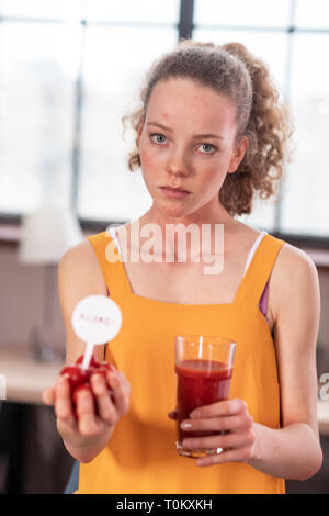 Poil long belle jeune femme tenant les légumes tout en présentant Banque D'Images