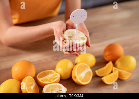 Agacé bon-à la femme ayant une allergie aux agrumes et fruits holding Banque D'Images