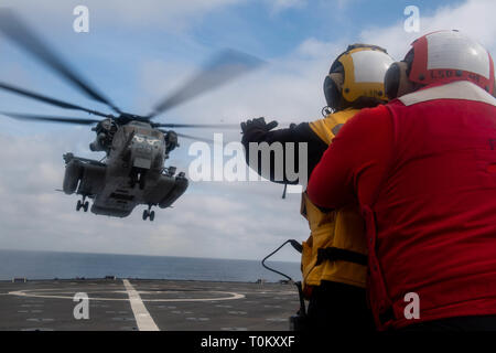 190319-N-HD110-0057 de l'OCÉAN PACIFIQUE (le 19 mars 2019) Gunner's Mate 2e classe Alexander Rangel, de Harrison, Ark., droite, accroche à Maître de Manœuvre 3 Classe Nicole Esparza, d'Austin, Texas, gauche parce qu'elle signale au pilote d'un CH-53E Super Stallion pour atterrir sur le pont d'envol du Harpers Ferry-class amphibious landing ship dock USS Harpers Ferry (LSD 49). Harpers Ferry est en cours, la réalisation des opérations de routine dans le cadre d'un groupe amphibie USS Boxer (ARG) dans l'océan Pacifique. (U.S. Photo par marine Spécialiste de la communication de masse 3 Classe Danielle A. Baker) Banque D'Images