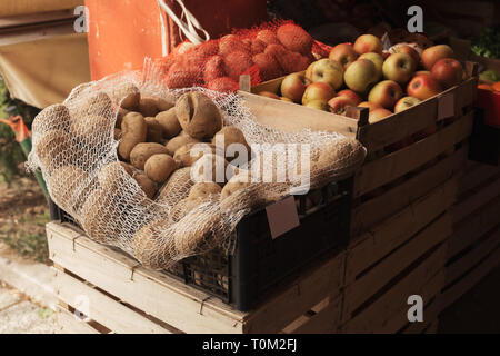 Pommes de terre et de pommes cultivées localement sur le marché de producteurs extérieurs placés dans des caisses en bois Banque D'Images