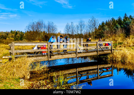 Trois générations d'une famille sur un pont sur les sentiers de randonnées de Silverdale Creek Les zones humides, un marais d'eau douce et marais près de Mission, C.-B. Banque D'Images