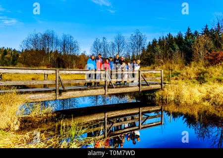 Trois générations d'une famille sur un pont sur les sentiers de randonnées de Silverdale Creek Les zones humides, un marais d'eau douce et marais près de Mission, C.-B. Banque D'Images