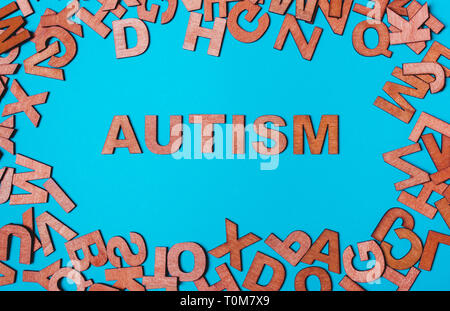 Le mot Autisme des lettres en bois sur un fond bleu. Le problème est dans la socialisation, la communication Banque D'Images