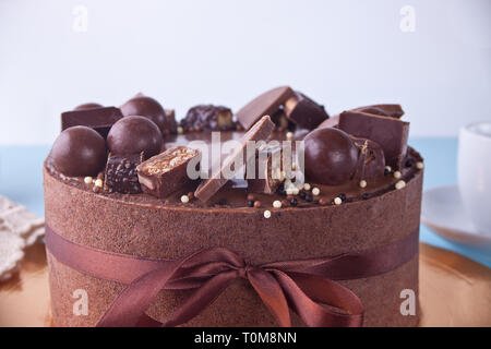 Gâteau d'anniversaire au chocolat avec des bonbons sur un tableau bleu Banque D'Images