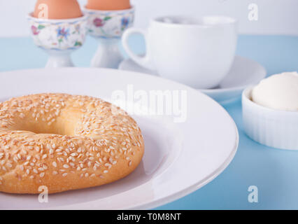Bagel frais sain sur la plaque blanche sur le tableau bleu. Banque D'Images