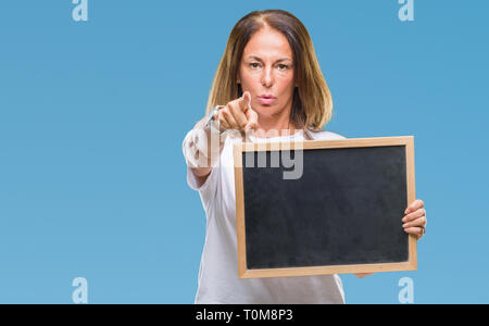 L'âge moyen hispanic woman holding tableau noir sur fond isolé pointant avec le doigt à la caméra et à la main, vous signe, positif et confiant Banque D'Images