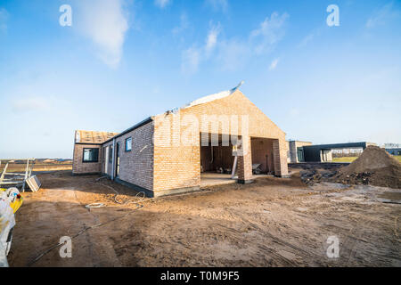 Maison de brique, site de construction en un nouveau quartier sous un ciel bleu Banque D'Images