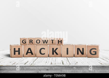 Hacking croissance signe sur un bureau en bois avec un mur gris en arrière-plan Banque D'Images