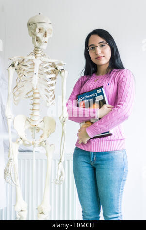 Une jeune femme d'origine asiatique étudiant travaillant dans le laboratoire de sciences d'un collège de Cambridge de procéder à une expérience de recherche Banque D'Images