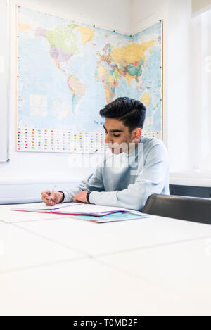 Un étudiant international studies difficile dans une salle de classe dans un collège à Cambridge Banque D'Images