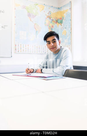 Un étudiant international studies difficile dans une salle de classe dans un collège à Cambridge Banque D'Images