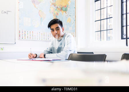 Un étudiant international studies difficile dans une salle de classe dans un collège à Cambridge Banque D'Images
