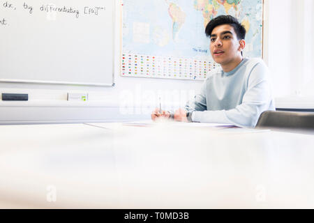 Un étudiant international studies difficile dans une salle de classe dans un collège à Cambridge Banque D'Images