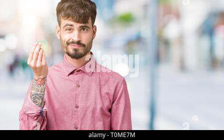 Beau jeune homme portant chemise rose sur fond isolé italien faisant geste avec la main et des doigts expression confiante Banque D'Images