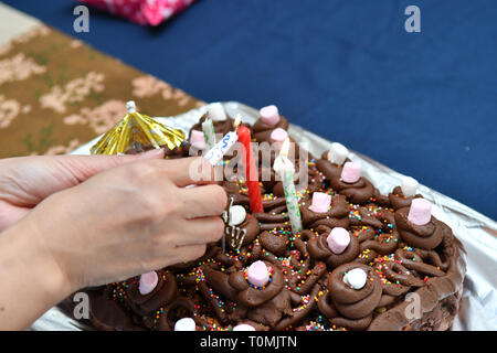 Close up - d'allumer des bougies sur un gâteau d'anniversaire Banque D'Images