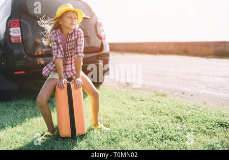 Adorable petite fille avec une valise de partir pour une location de vacances avec leurs parents. Banque D'Images