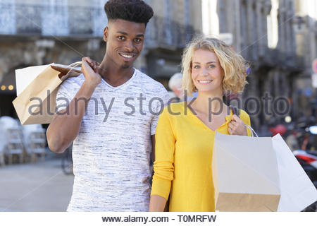 Jeune couple multiethnique avec des sacs à l'extérieur Banque D'Images