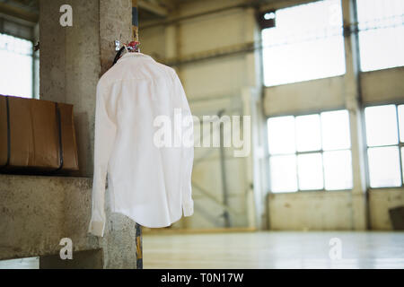 Photo de chemise blanche accroché dans warehouse Banque D'Images