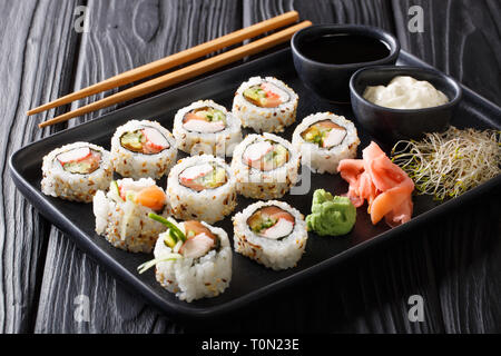 Uramaki saumon asiatique rouleaux de crabes et gros plan sur une plaque horizontale sur la table. Banque D'Images