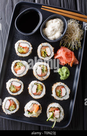 Ensemble de rouleaux japonais servis avec des sauces, uramaki gingembre et wasabi libre sur une plaque sur la table. Haut Vertical Vue de dessus Banque D'Images