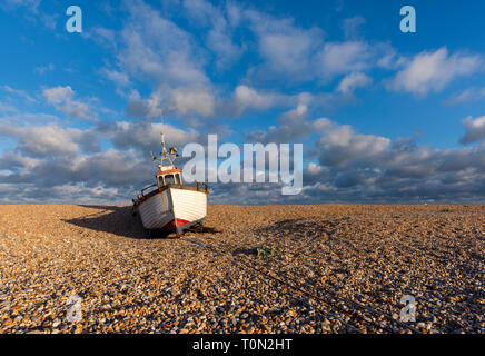 Un seul bateau de pêche sur les étendues de galets à Dungeness, Kent. Banque D'Images