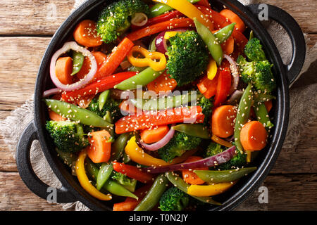 Végétariens délicieux sauté de légumes au sésame close-up dans un bol sur la table, horizontal haut Vue de dessus Banque D'Images