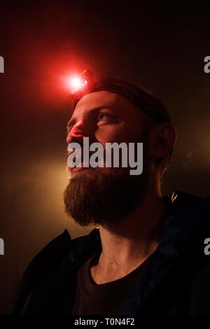 Close-up portrait d'un courageux jeune homme barbu avec un feu rouge sur son front Banque D'Images