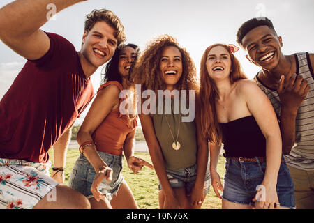 Multi-ethnic group of friends ensemble à s'amuser. Heureux les jeunes gens qui dansaient à l'extérieur. Groupe d'amis profitant des vacances d'été. Banque D'Images