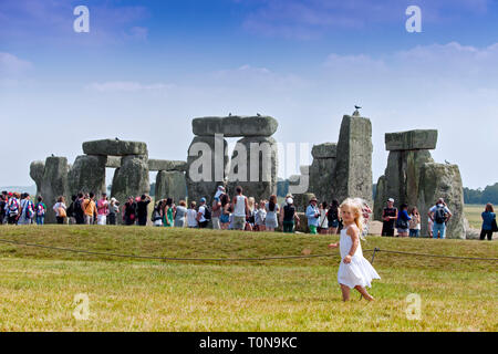 L'Europe, Royaume-Uni, Angleterre, dans le Wiltshire. Jeune fille qui marche autour de Stonehenge à l'été. Banque D'Images