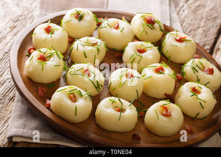 Des boulettes de pommes de terre aux lardons et oignons verts close-up sur une plaque sur la table horizontale. Banque D'Images