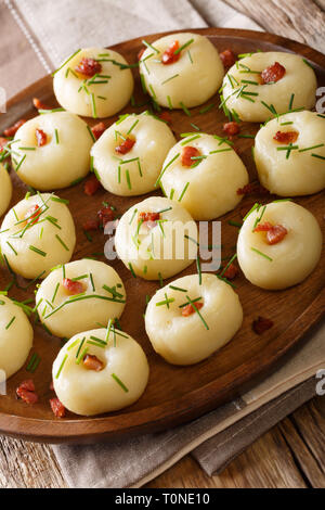 Polish boulettes de pommes de terre aux lardons et oignons verts gros plan sur une plaque verticale sur la table. Banque D'Images