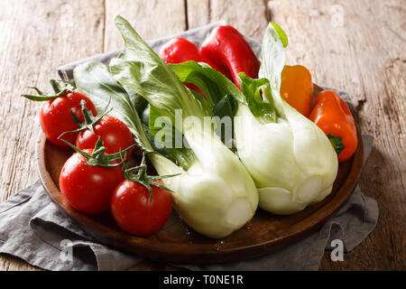 Style rustique des légumes comme des petits bok choy, les tomates et les poivrons sur une plaque sur une table de bois horizontal. Banque D'Images