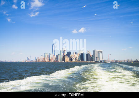 Manhattan vu de la liberté d'utiliser Staten Island Ferry, avec un troupeau de mouettes qui suit. Banque D'Images