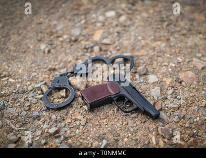 Pistolet et menottes sur la masse. Focus sélectif. Profondeur de champ. Banque D'Images