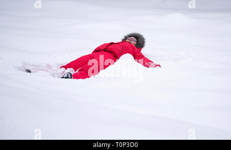 Fille dans la fabrication de la neige un ange, profitant de l'hiver. Activité d'amusement pour essayer en cette saison dans tous les parcs Banque D'Images