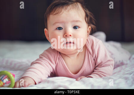 Closeup portrait of cute adorable Asian mixed race baby girl 4 mois allongé sur son ventre à huis clos. Visage naturel d'expression. L'enfance Banque D'Images