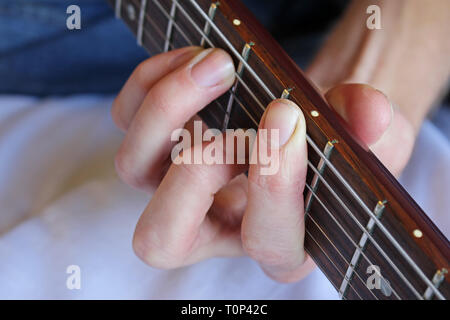 La main du joueur de guitare formant un accord sur le manche d'une guitare. Banque D'Images