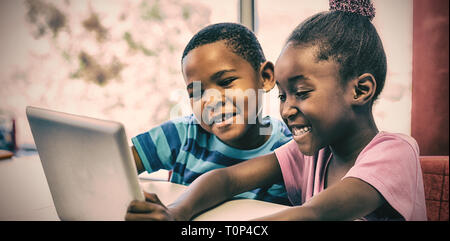 Smiling children using digital tablet in classroom Banque D'Images