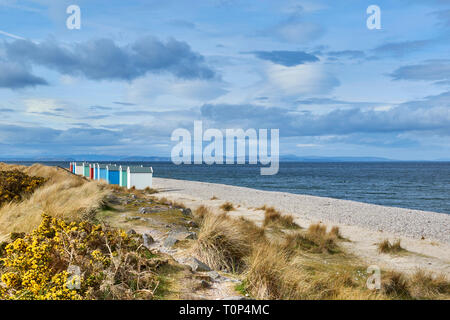 Plage de FINDHORN MORAY ECOSSE dix chalets colorés ou des cabanes de plage NEIGE SUR LES COLLINES ET BLACK ISLE Banque D'Images