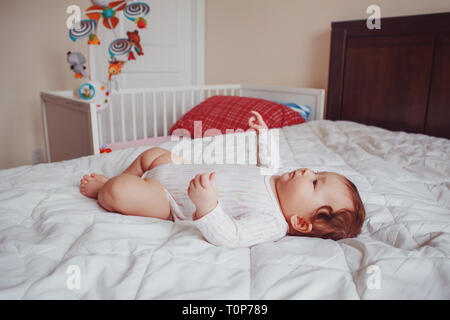 Portrait of cute adorable Asian mixed race baby girl 4 mois allongé sur lit dans la chambre. L'émotion naturelle face à l'expression. La diversité de la petite enfance FRV Banque D'Images