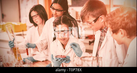 Les enfants faisant l'école à l'écoute une expérience chimique in laboratory Banque D'Images